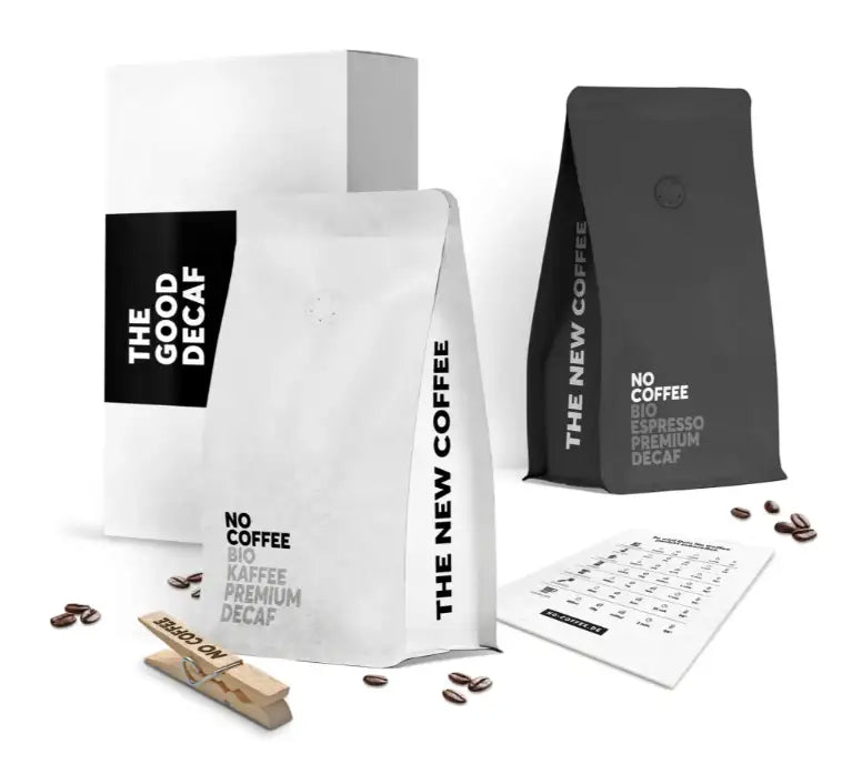Weiße und schwarze Kaffeebohnen-Beutel mit minimalistischer Typografie, mit „„die gute koffeinfreie““ auf einem weißen Beutel und „„kein Kaffee Bio Espresso Premium koffeinfrei““ vertikal in Grau gedruckt.